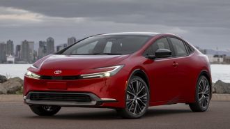 The totally redesigned 2023 Toyota Prius in red, as seen from the front.