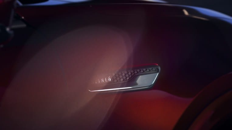 A teaser photo showing a badge on the upcoming Mazda CX-90