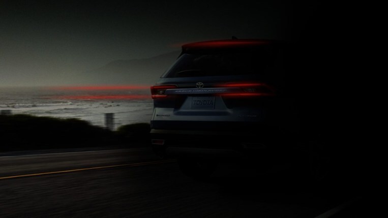 A teaser photo showing the rear of the 2024 Toyota Grand Highlander obscured by shadows