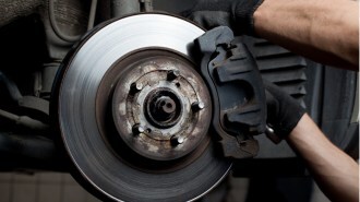 A mechanic working on a car's brake pads