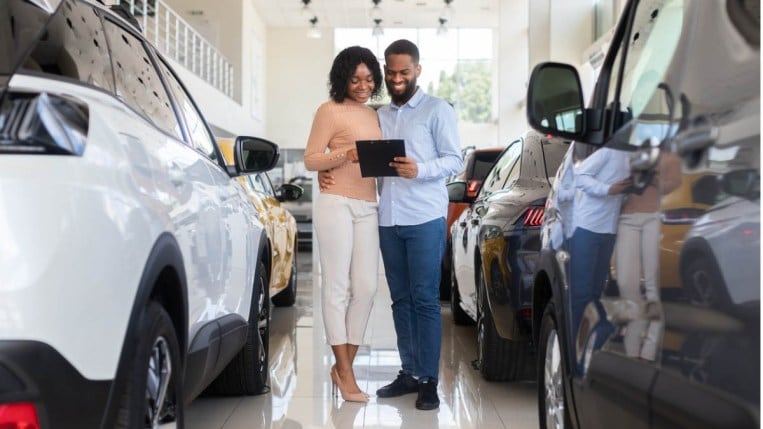 Young couple shopping in a car dealership