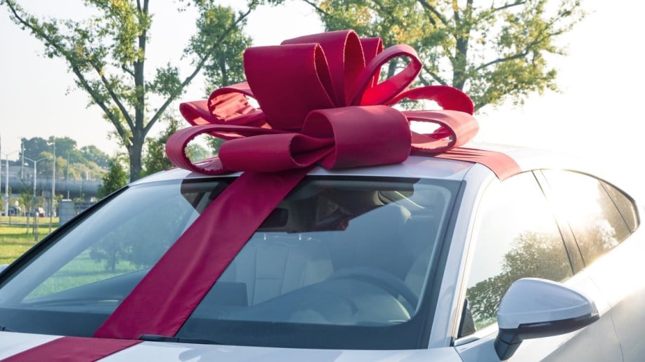 A giant red bow sits atop a new car