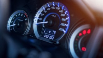 A closeup of a car's dashboard showing a digital odometer
