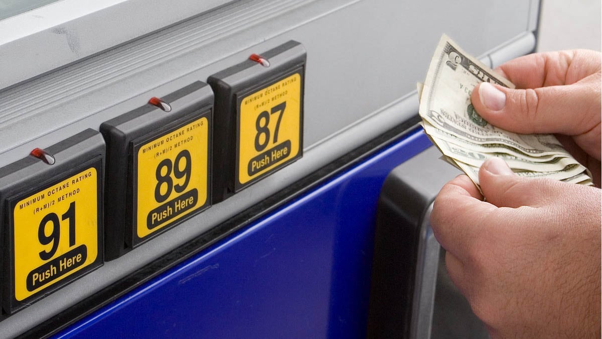 A person with cash at gas pump