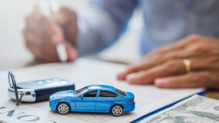 Person signing a car loan agreement