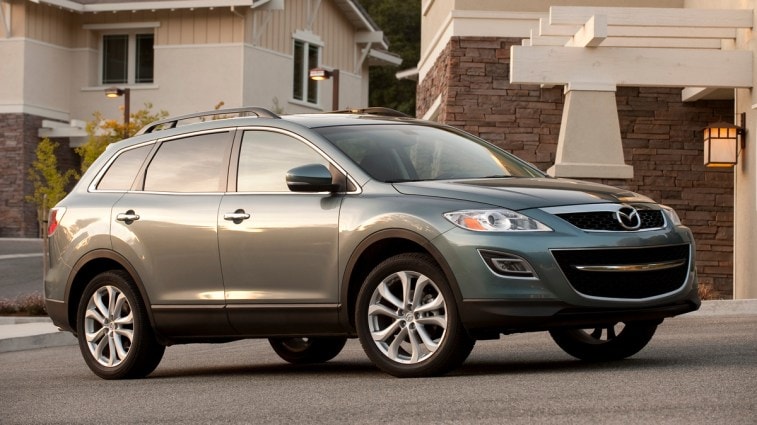 Grey 2012 Mazda CX-9 at sunset near stone wall.