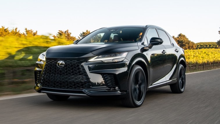 2023 Lexus RX 500h F-Sport driving near an orchard.