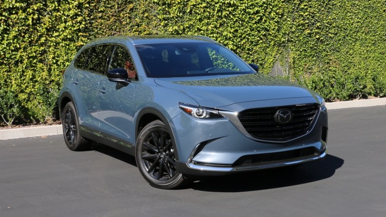 2023 Mazda CX-9 Carbon Edition near green backdrop.