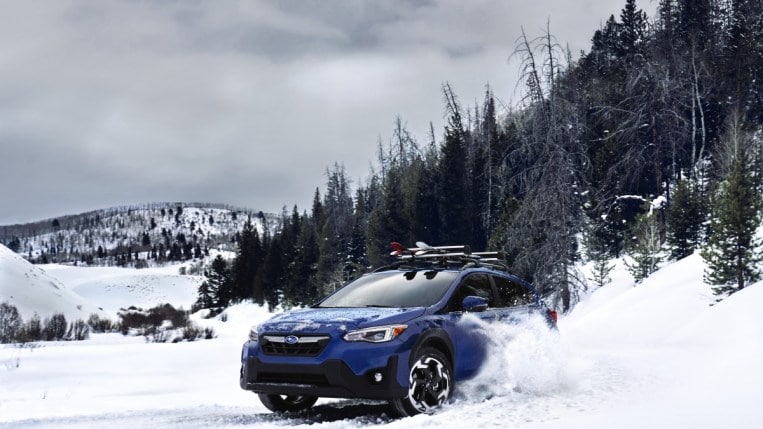 The 2023 Subaru Crosstrek seen driving off-road through snow