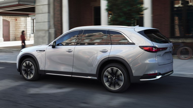White 2024 Mazda CX-90 driving in the city.