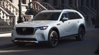White 2024 Mazda CX-90 PHEV parked near steps.