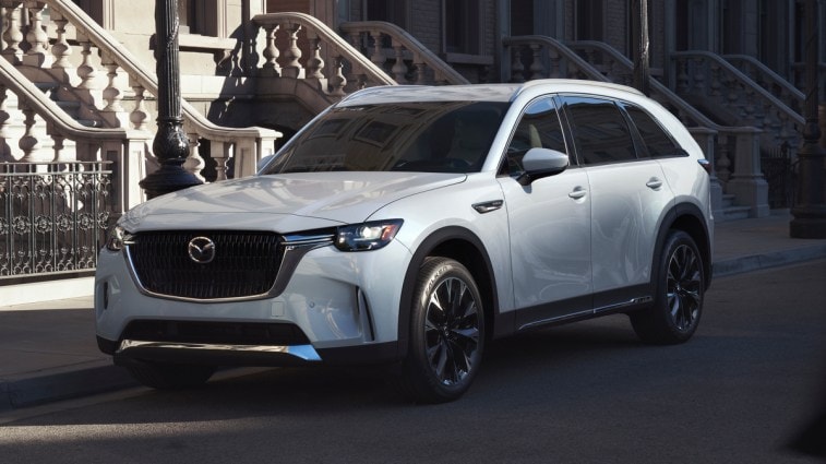 White 2024 Mazda CX-90 PHEV parked near steps.