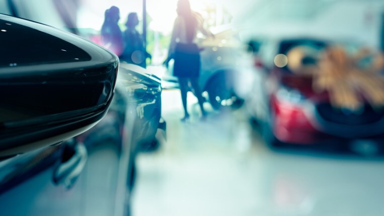 A side mirror and blurred dealership showroom