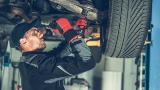 A technician working on a shocks and struts repair