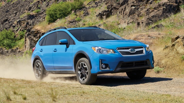 Blue 2017 Subaru Crosstrek driving on dirt road.