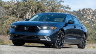 Blue 2023 Honda Accord Hybrid near rocky hills.