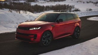 Red 2023 Range Rover Sport Deer Valley Edition driving near snow.