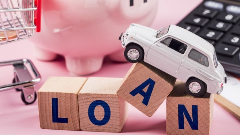 A toy car on top of blocks spelling out the word loan