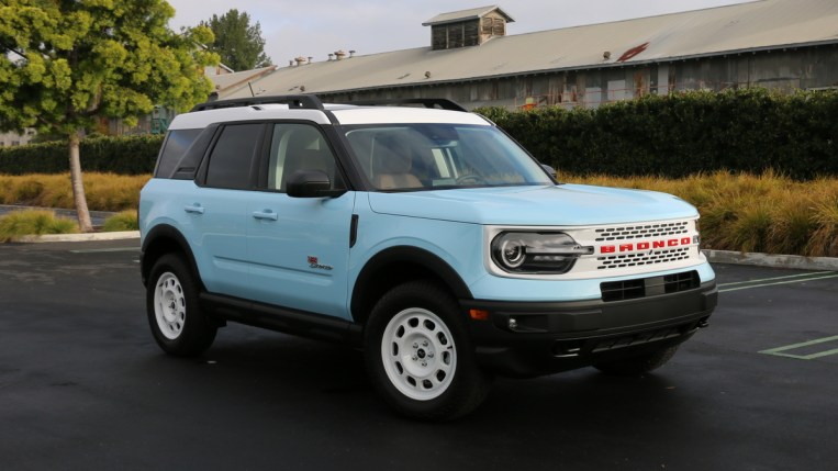 A blue 2023 Ford Bronco Sport Heritage is parked near a metal hangar.