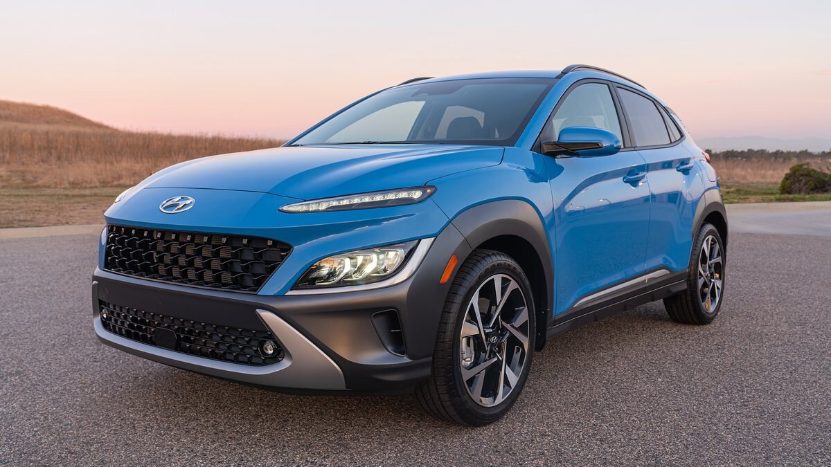 Blue 2023 Hyundai Kona Limited parked near brown field.