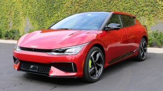 Red 2023 Kia EV6 GT near green wall.