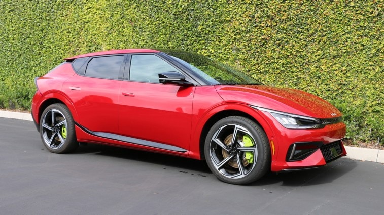 Red 2023 Kia EV6 GT near green wall.