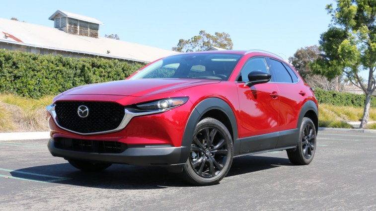 Red 2023 Mazda CX-30 with a green hedge in the background.