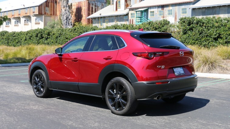 Red 2023 Mazda CX-30 rear 3qtr view near metal barn.