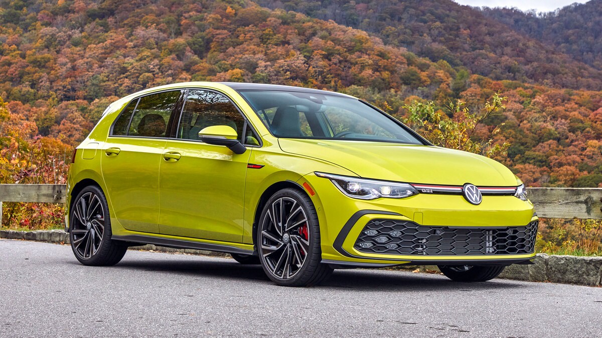 2023 Volkswagen Golf GTI in lime near a hillside.