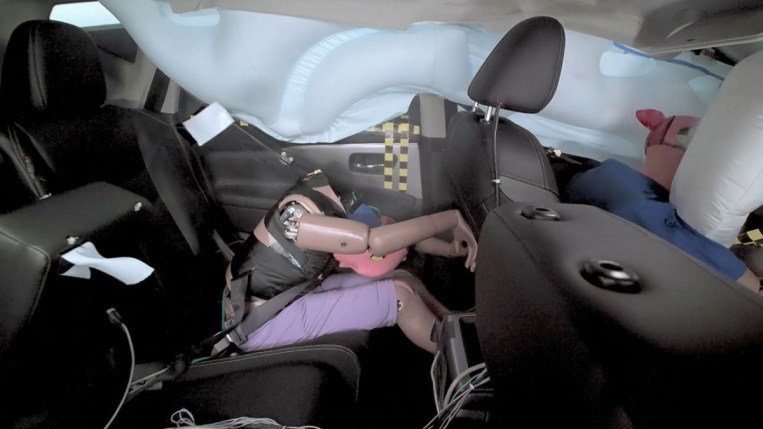 A rear-seat crash dummy during an IIHS frontal overlap crash test of a 2022 Nissan Murano