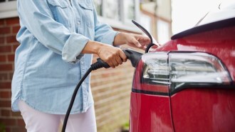 A driver plugs in an EV to charge at home