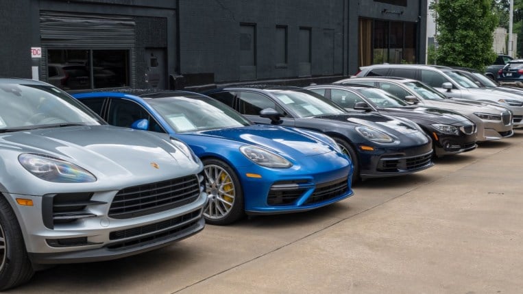Cars lined up for sale at a Porsche dealership