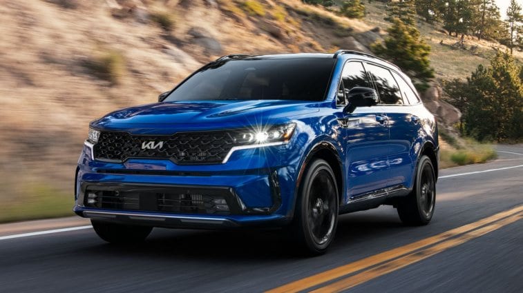 Kia Sorento SX 2023 bleu roulant sur une route de montagne.