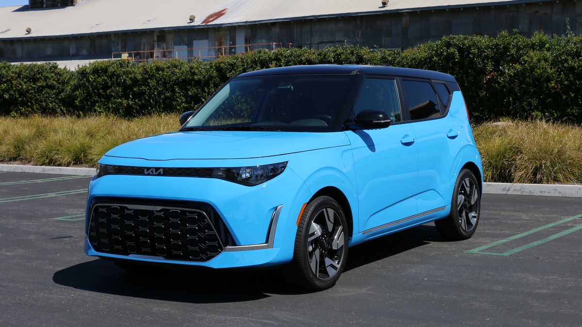Blue 2023 Kia Soul GT-Line near a green hedge.