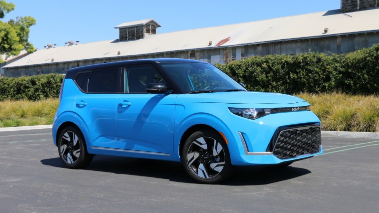 Blue 2023 Kia Soul GT-Line near a green hedge.