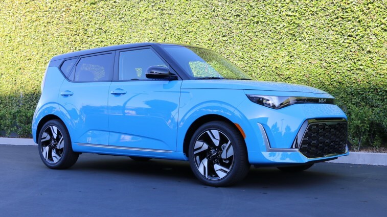 Blue 2023 Kia Soul GT-Line near a green wall.