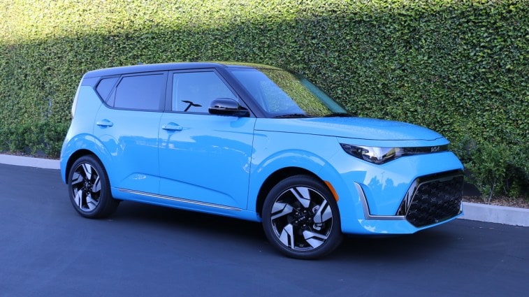 Blue 2023 Kia Soul GT-Line near a green wall.