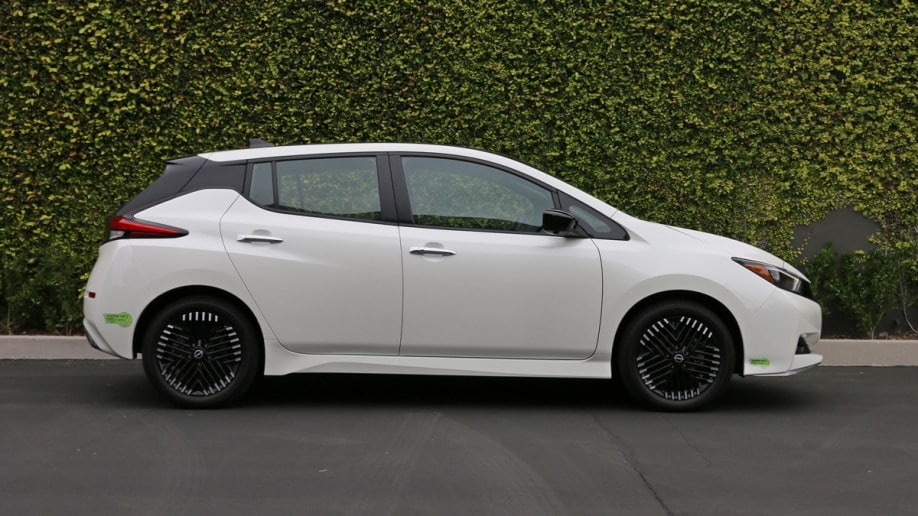 White 2023 Nissan Leaf near ivy wall.