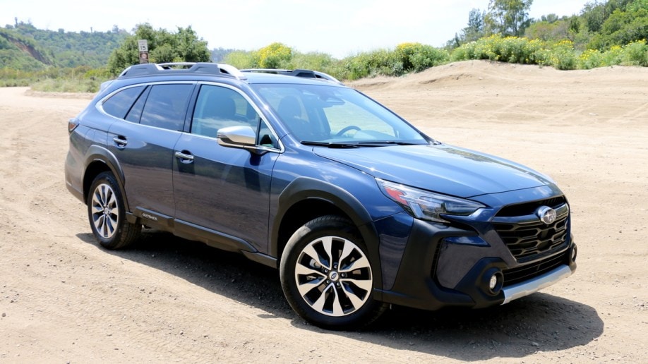 Blue 2023 Subaru Outback Touring on a dirt road.