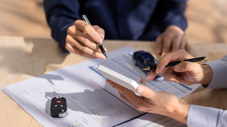 two people processing a car purchase transaction