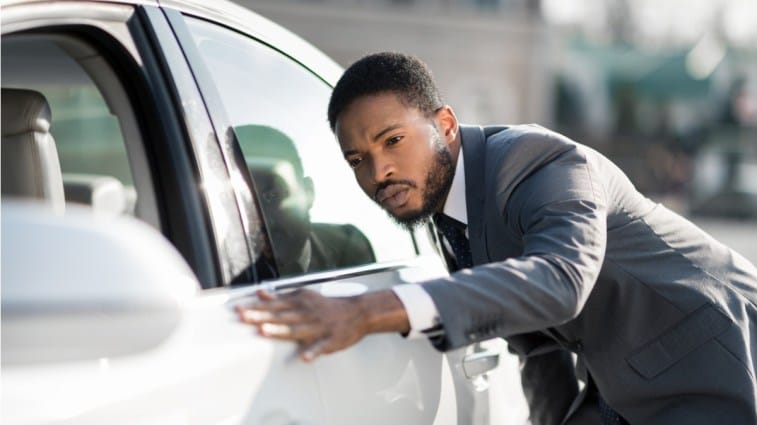 Person checking car exterior at test drive.