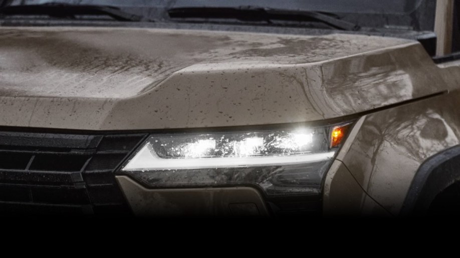 A teaser photo showing one headlight of the upcoming 2024 Lexus GX