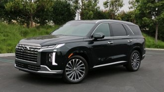 2023 Hyundai Palisade Calligraphy in emerald green near trees.