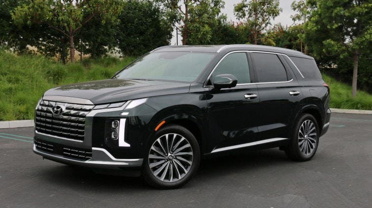 2023 Hyundai Palisade Calligraphy in emerald green near trees.