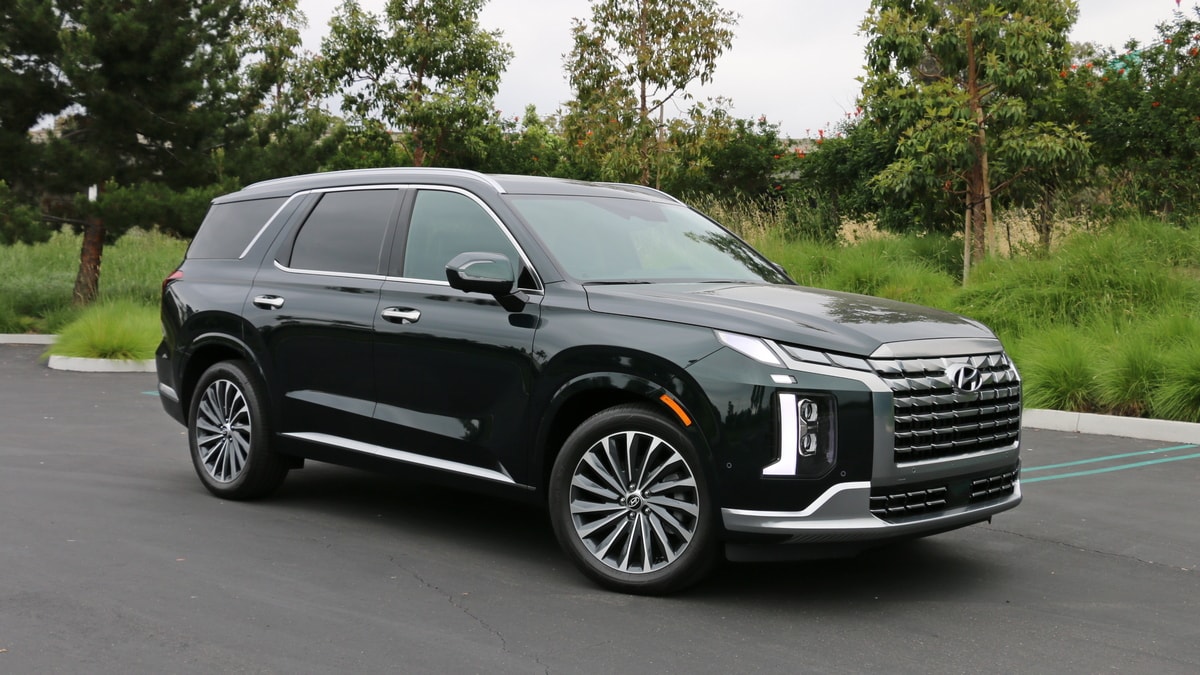 2023 Hyundai Palisade Calligraphy in emerald green near tall grass.