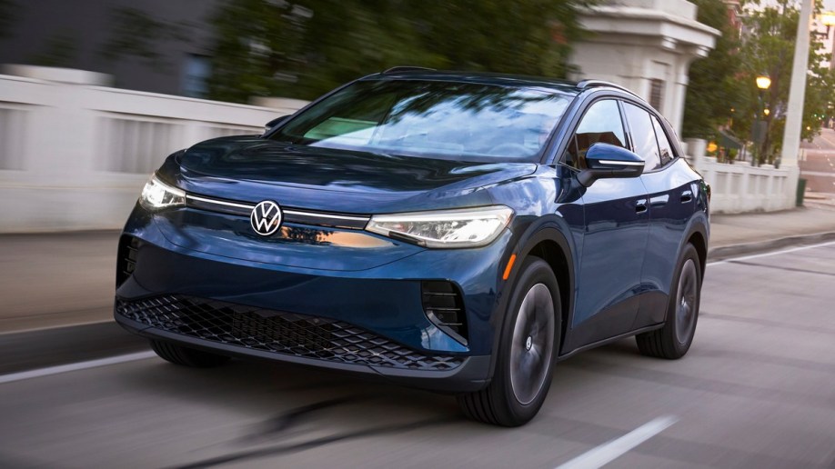 2023 Volkswagen ID.4 in blue driving by a city bridge.