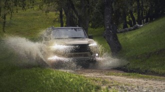 The 2024 Lexus GX splashes through a puddle