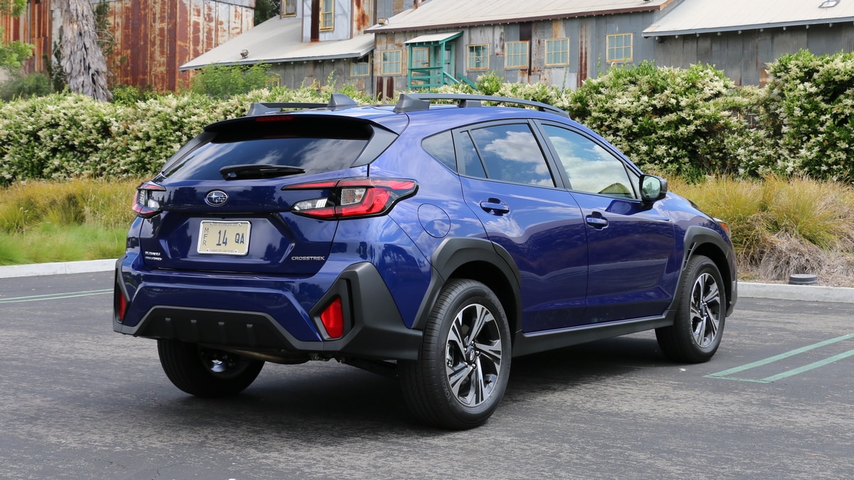 2024 Subaru Crosstrek in blue with metal barn in background.