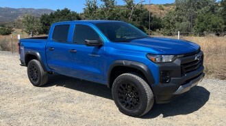 2023 Chevrolet Colorado Trail Boss in blue with trees in the background.
