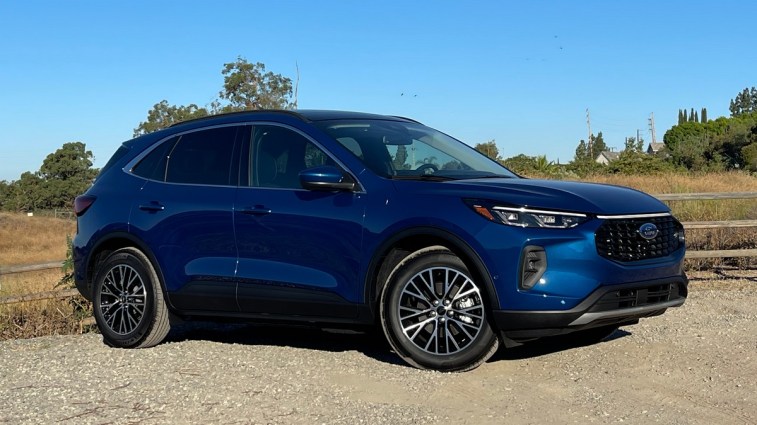 2023 Ford Escape PHEV in blue near wooden fence.